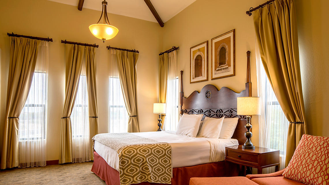 Guest room with exposed beams and elegant curtains